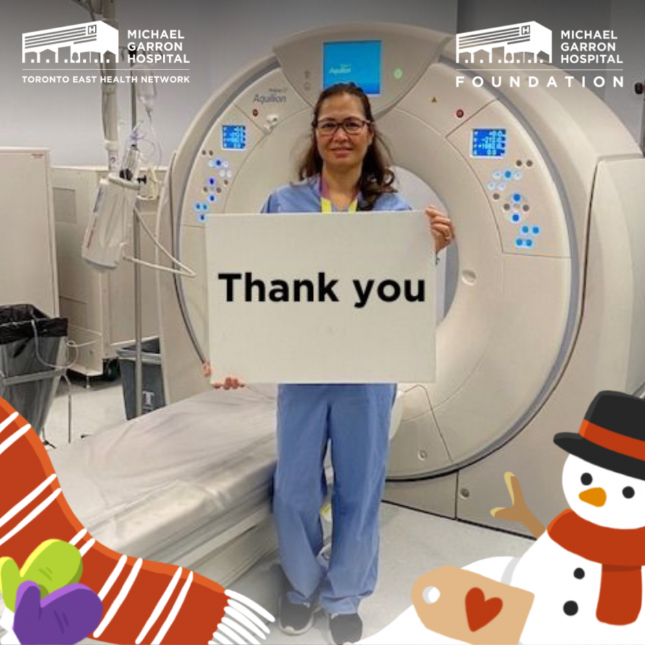 Lady in front of MRI machine holding a Thank You sign