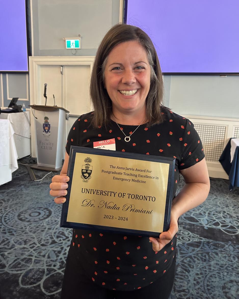 Dr. Nadia Primani holding a plaque.