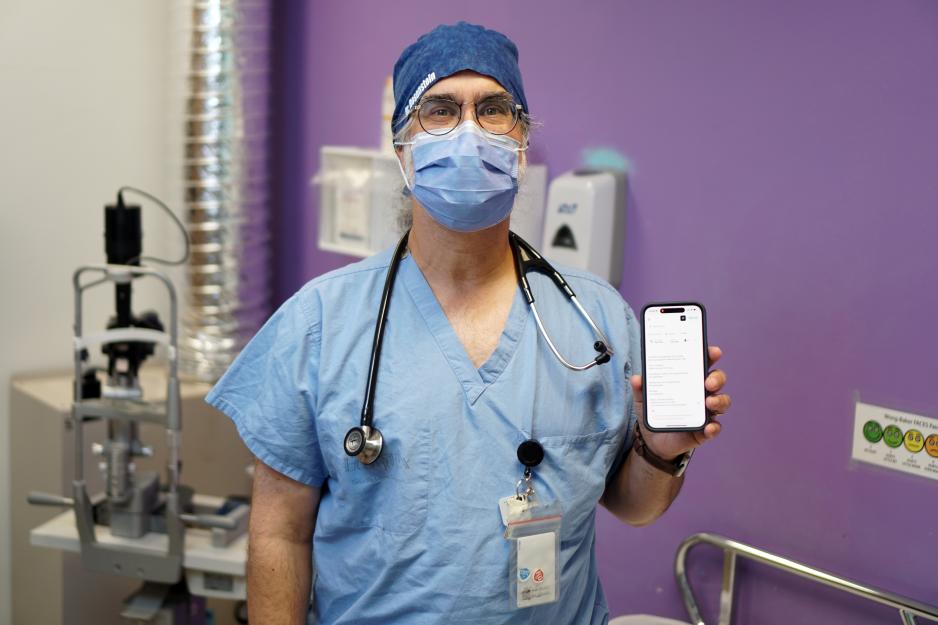 Dr. David Rosenstein, Emergency Physician and Information Technology Lead in MGH’s ED, holds a smartphone displaying the Ambient Scribe tool.