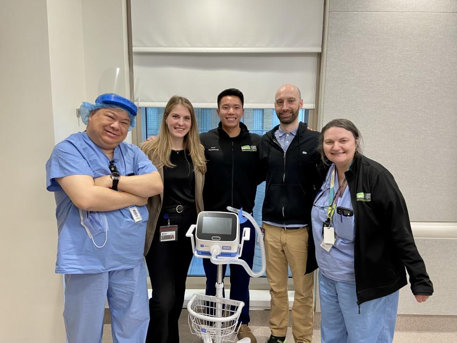 Healthcare workers smiling and standing around the Synclara cough machine.