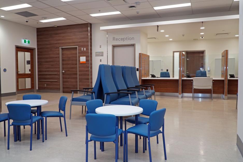 Waiting room with large chairs for adults and small tables and chairs for children.