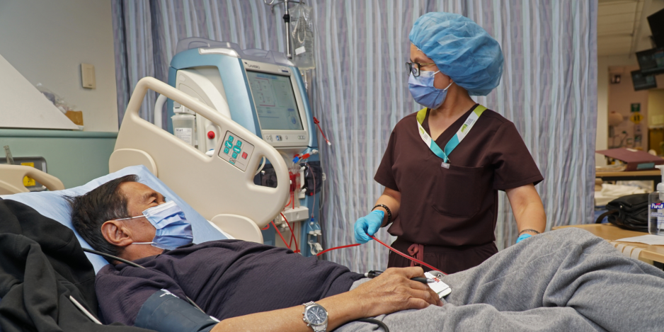 Medical professional by patient bedside.