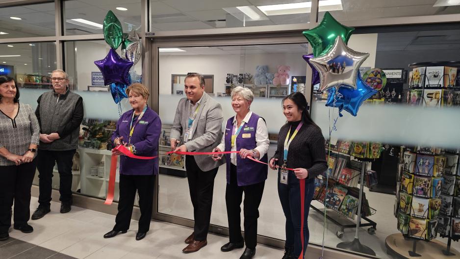 MGH staff and volunteers stand together during a ribbon-cutting ceremony, marking The General Store’s new location.