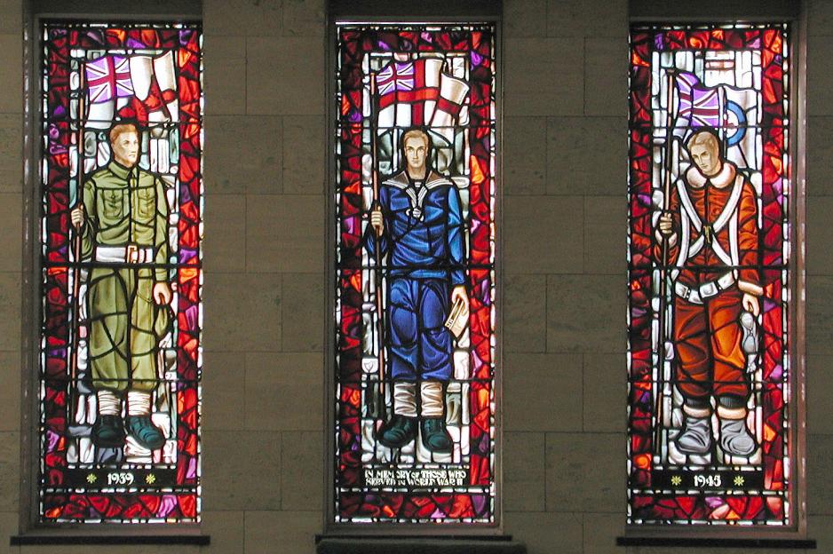 Three Second World War stained-glass windows showing a Canadian Army Soldier (left), Royal Canadian Navy Serviceman (centre) and Royal Canadian Air Force Pilot (right) with colourful backgrounds.