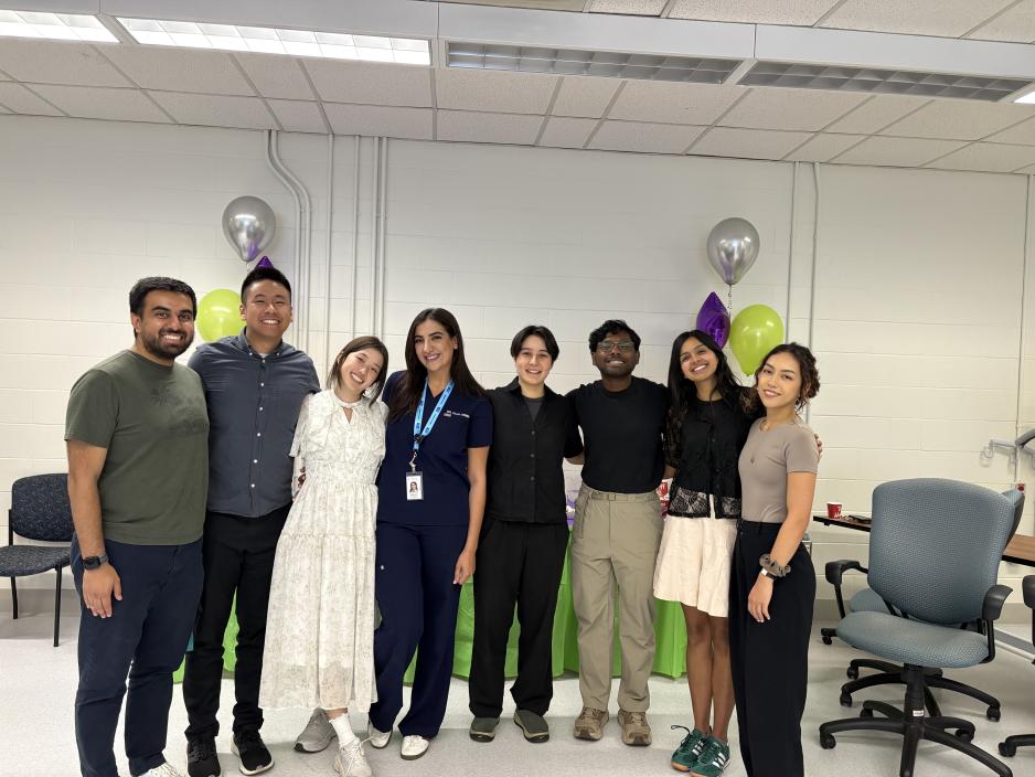 A group of medical residents stand smiling at the camera on their orientation day