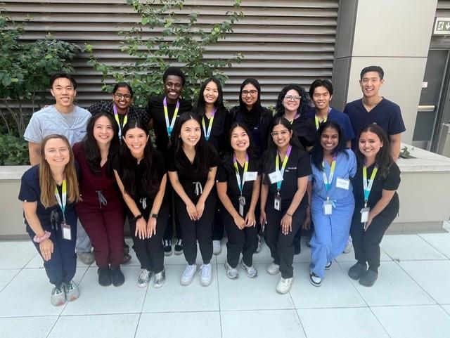 Sixteen family medicine residents smile at the camera on orientation day