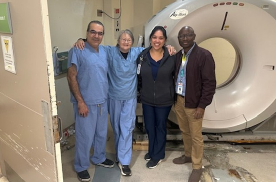 Clinicians standing in front of CT scanner.